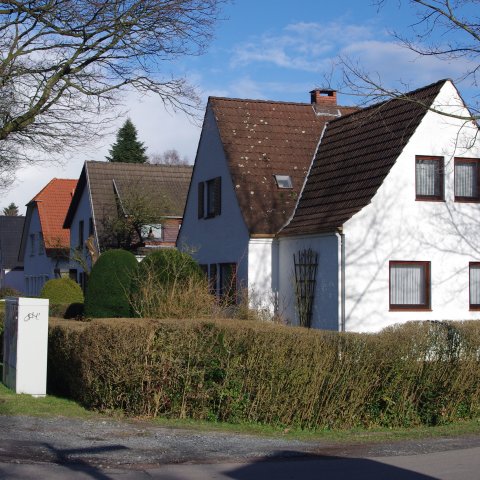 Eine Reihe mit vielen freistehenden Häusern an einer Straße. Eine Reihe mit vielen freistehenden Häusern an einer Straße.